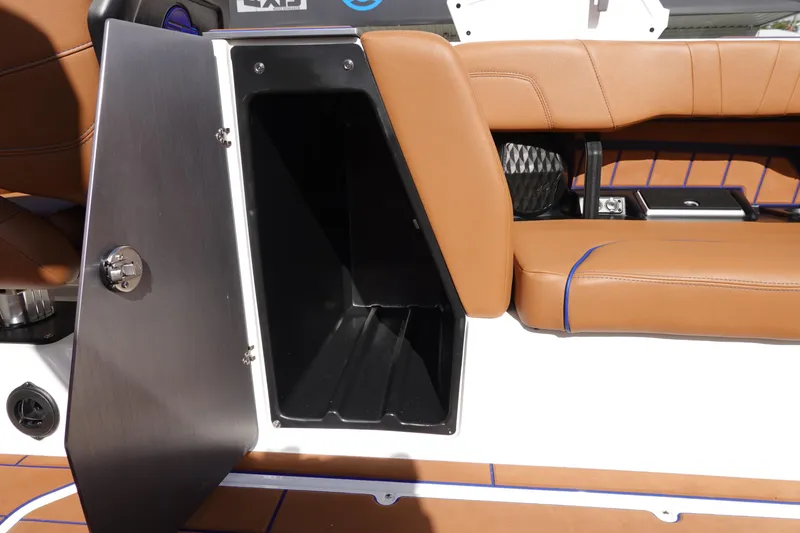 Slide: The Image of 2023 Malibu Wakesetter 24 MXZ storage compartment with brown leather seating. - 23
