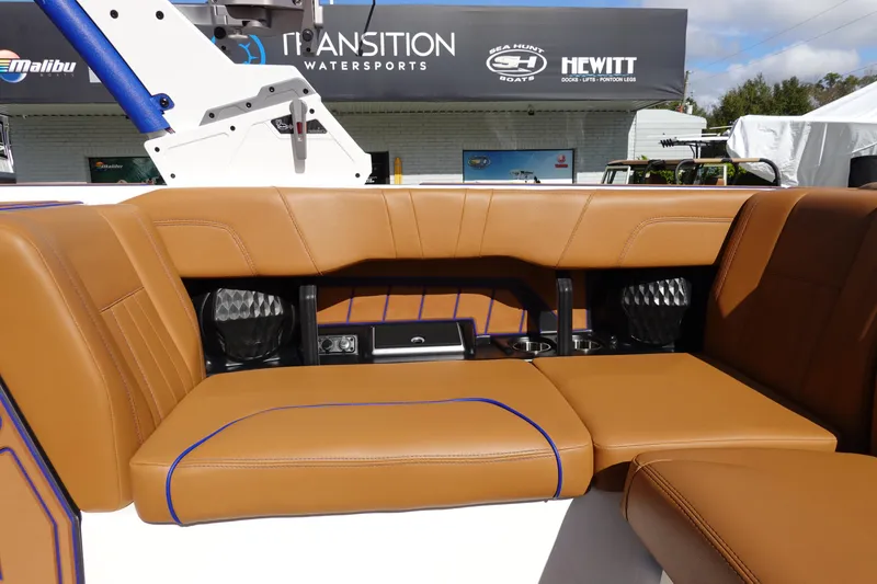 Slide: The Image of 2023 Malibu Wakesetter 24 MXZ interior seating with tan upholstery and blue accents. - 24