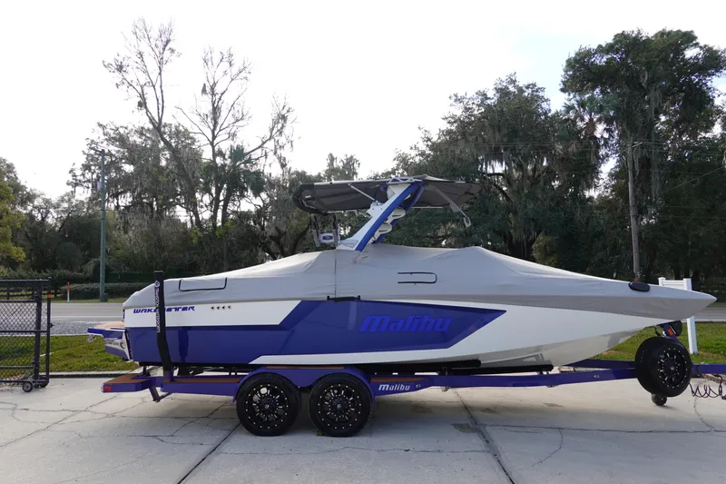 Slide: The Image of 2023 Malibu Wakesetter 24 MXZ boat on a trailer, covered and parked outdoors. - 44
