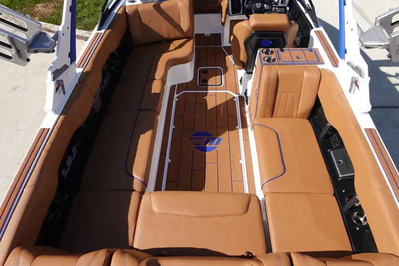 Slide: The Image of 2023 Malibu Wakesetter 24 MXZ interior with tan leather seating and wood flooring. - 8
