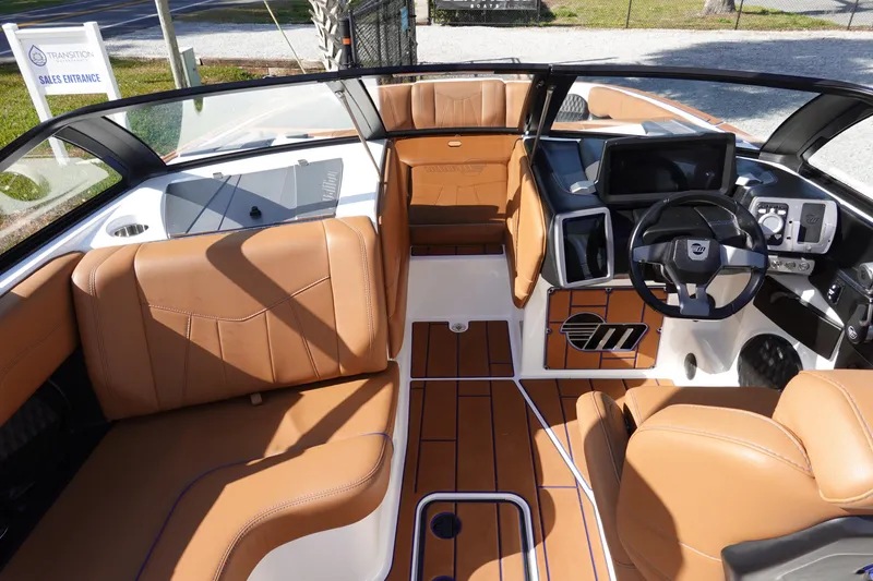 Slide: The Image of 2023 Malibu Wakesetter 24 MXZ boat interior with tan leather seats and modern dashboard. - 9