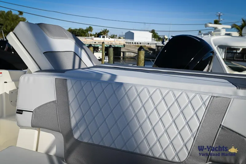 Slide: The Image of 2024 Bayliner VR5 boat with diamond-stitched upholstery, docked at a marina. - 14