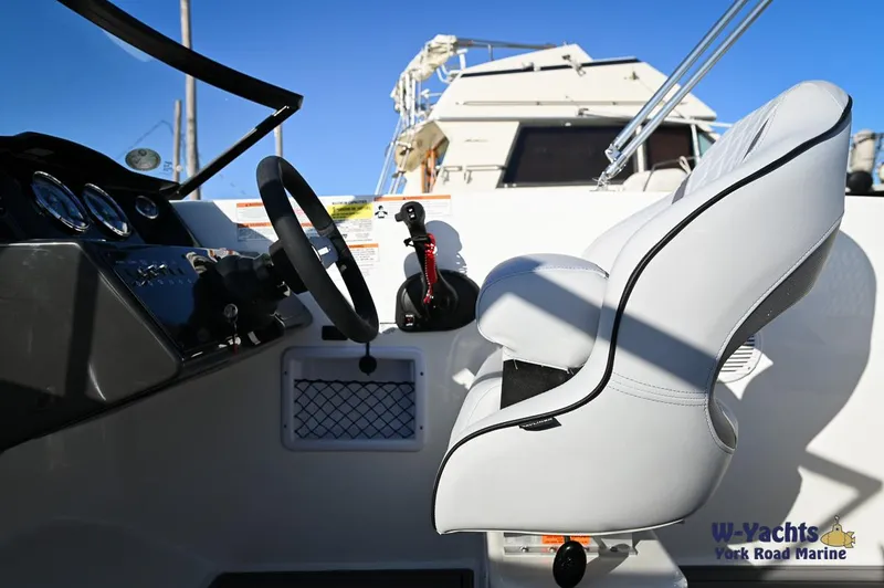 Slide: The Image of 2024 Bayliner VR5 boat cockpit with steering wheel and white captain's chair. - 17