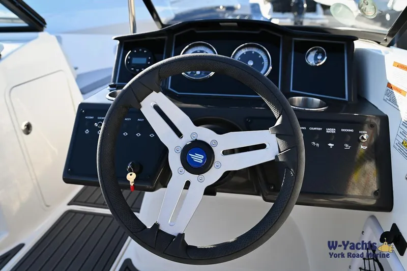 Slide: The Image of 2024 Bayliner VR5 boat steering wheel and dashboard controls. - 19