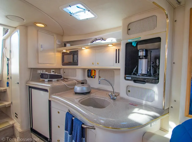 Slide: The Image of Interior of 1999 Sea Ray 340 Sundancer yacht kitchen with modern amenities. - 12