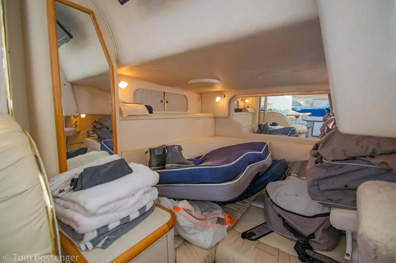 Slide: The Image of 1999 Sea Ray 340 Sundancer cabin interior with cozy seating and storage. - 17