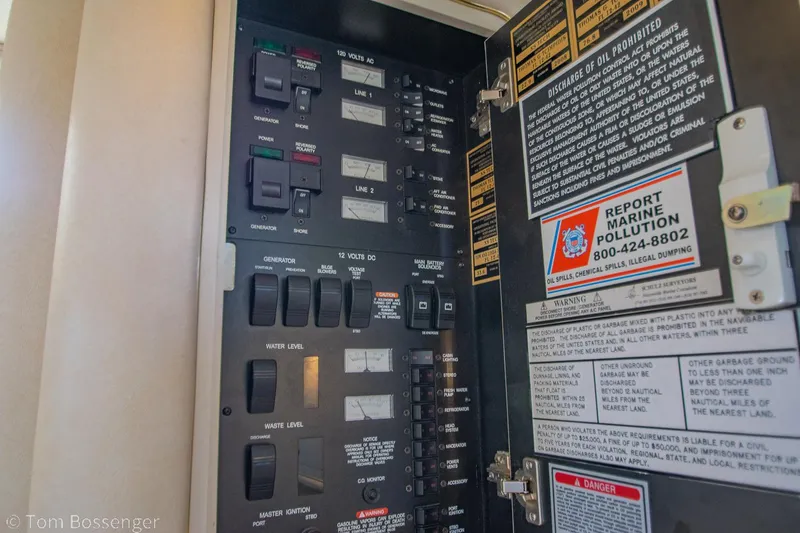 Slide: The Image of Electrical panel inside a 1999 Sea Ray 340 Sundancer boat, featuring various switches and safety notices. - 20