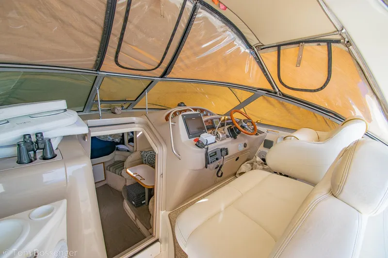 Slide: The Image of 1999 Sea Ray 340 Sundancer cockpit with beige interior and navigation equipment. - 21