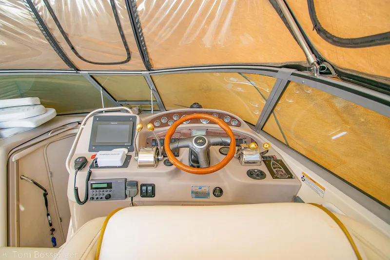 Slide: The Image of 1999 Sea Ray 340 Sundancer helm with wood steering wheel and navigation equipment. - 22