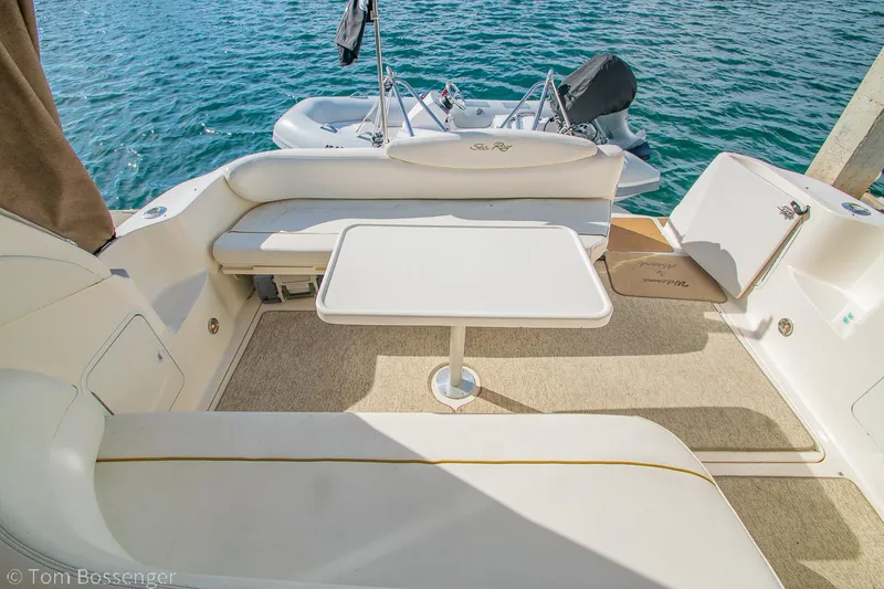 Slide: The Image of 1999 Sea Ray 340 Sundancer boat interior with seating and table, overlooking water. - 30