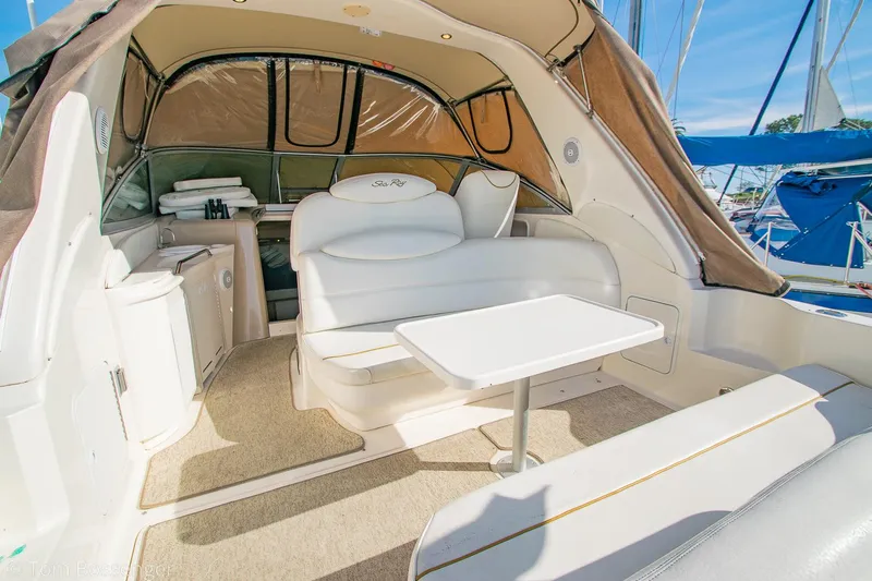 Slide: The Image of 1999 Sea Ray 340 Sundancer interior with seating, table, and canopy in a marina setting. - 31