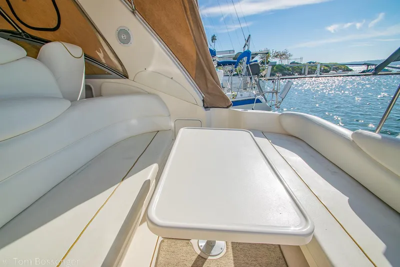 Slide: The Image of 1999 Sea Ray 340 Sundancer boat interior with seating and table, overlooking water. - 32