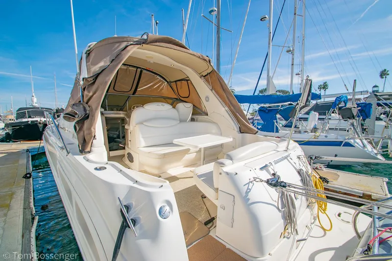 Slide: The Image of 1999 Sea Ray 340 Sundancer yacht docked at marina, featuring spacious seating and canopy. - 6