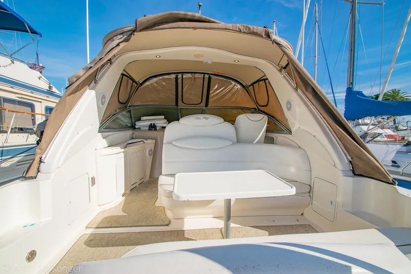 Slide: The Image of 1999 Sea Ray 340 Sundancer boat interior with seating and table, docked at marina. - 7