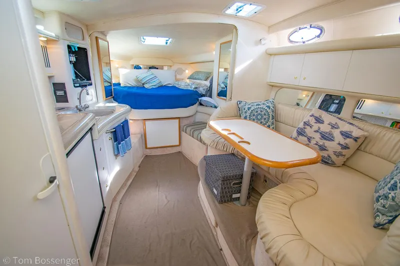 Slide: The Image of 1999 Sea Ray 340 Sundancer cabin interior with cozy seating and kitchenette. - 8