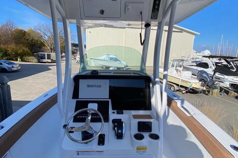 Slide: The Image of 2024 Sea Pro 242 boat dashboard with steering wheel and navigation system. - 5