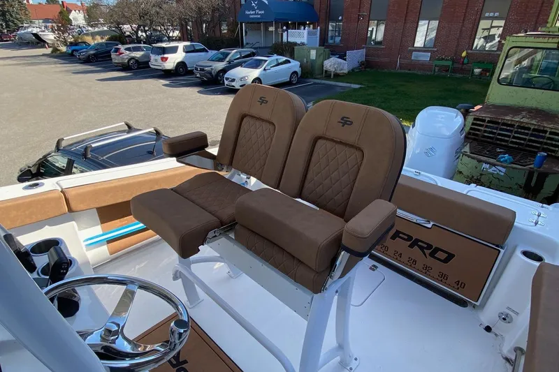 Slide: The Image of 2024 Sea Pro 242 boat with brown cushioned seats and steering wheel. - 6