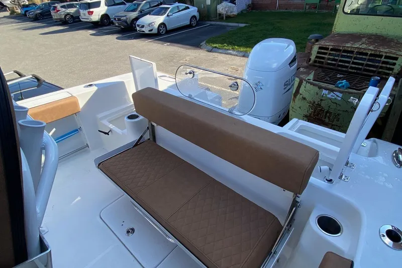 Slide: The Image of 2024 Sea Pro 242 boat with brown seating and white exterior in a parking lot. - 8