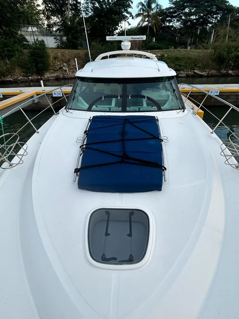 Slide: The Image of 2013 Sea Ray 410 Sundancer yacht docked, featuring sleek design and spacious deck. - 2