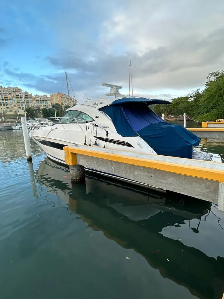 Slide: The Image of 2013 Sea Ray 410 Sundancer yacht docked at marina with blue canopy. - 3