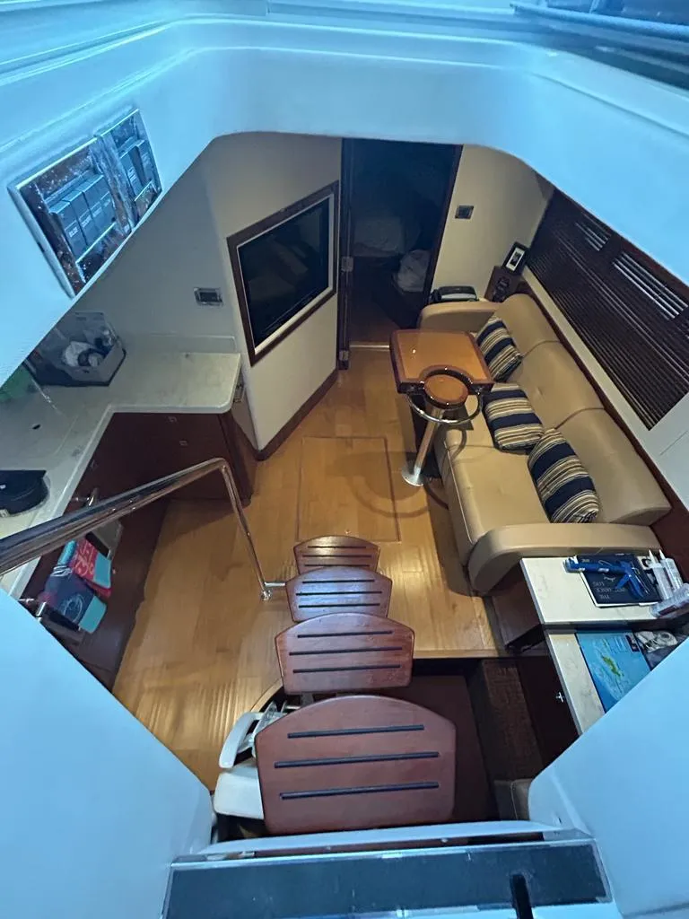 Slide: The Image of Interior of 2013 Sea Ray 410 Sundancer yacht with modern seating and wooden flooring. - 8