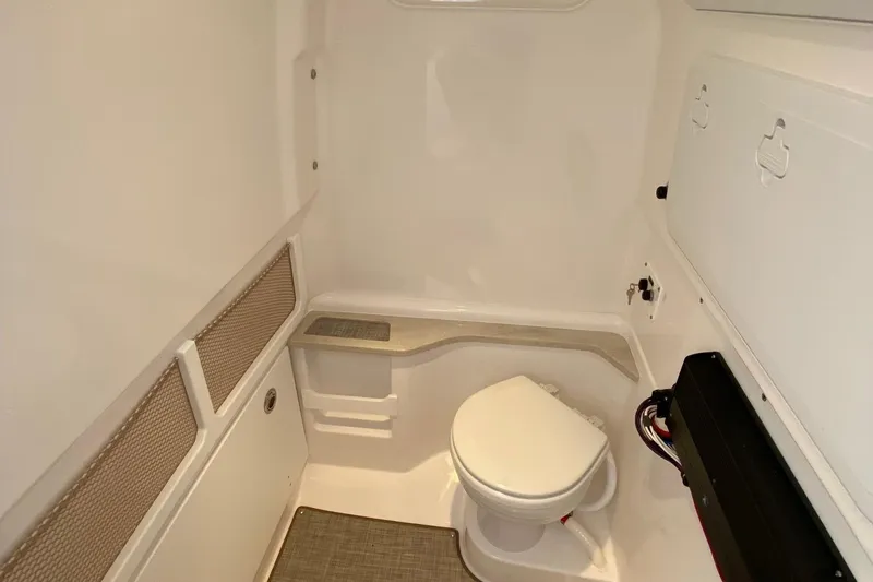 Slide: The Image of 2023 Everglades 273 boat interior bathroom with toilet and storage compartments. - 6