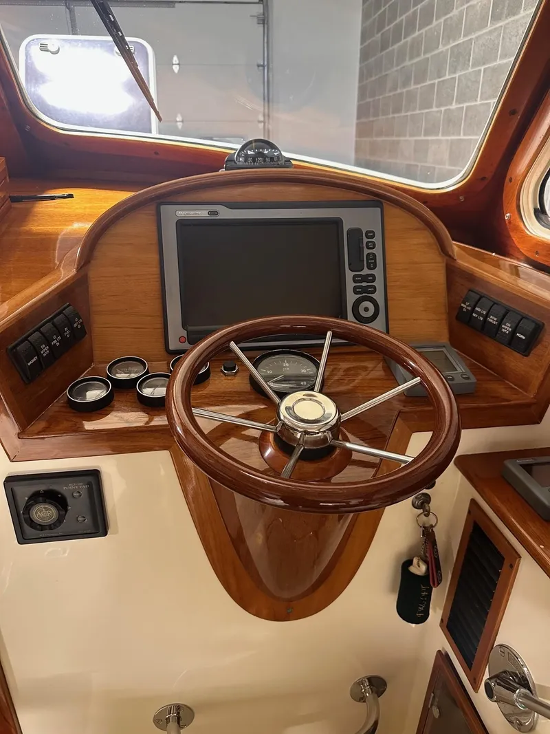 Slide: The Image of Hinckley 36 Picnic Boat 2001 helm with wooden steering wheel and navigation system. - 10
