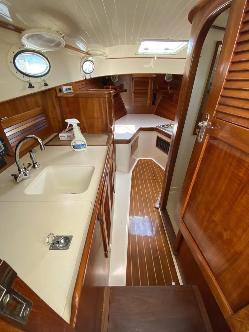 Slide: The Image of Interior of 2001 Hinckley 36 Picnic Boat with wooden finishes and compact kitchen. - 7