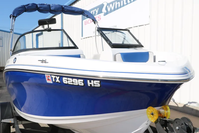 Slide: The Image of 2020 Tahoe 450 TS boat with blue hull and white interior on trailer. - 11