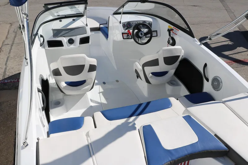 Slide: The Image of 2020 Tahoe 450 TS boat interior with white and blue seating, steering wheel, and dashboard. - 12
