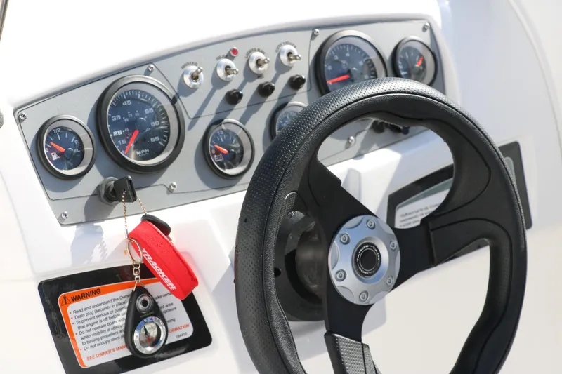 Slide: The Image of 2020 Tahoe 450 TS boat dashboard with steering wheel and control gauges. - 21