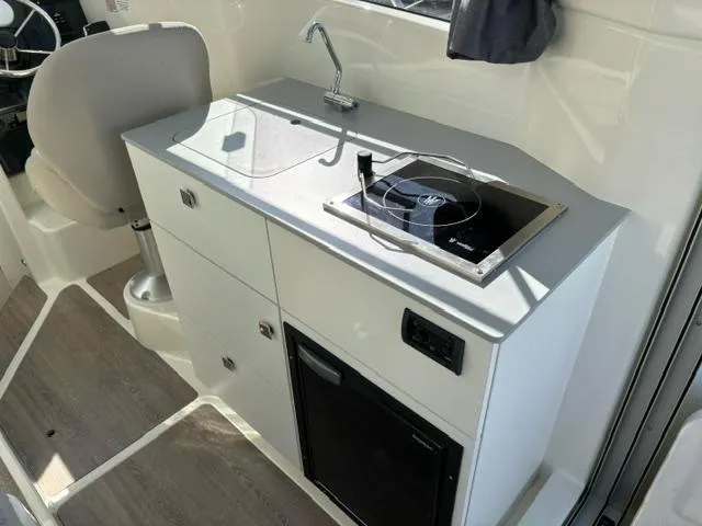 Slide: The Image of Compact kitchen area in 2024 Bayliner TROPHY 25 EXPLORER boat with sink and stove. - 10