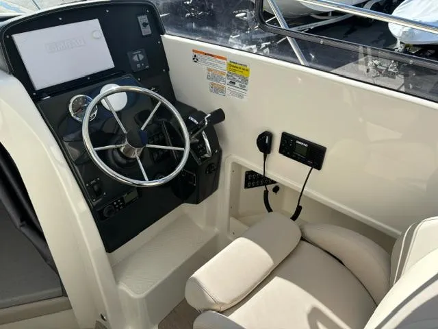 Slide: The Image of 2024 Bayliner TROPHY 25 EXPLORER helm station with steering wheel and control panel. - 11
