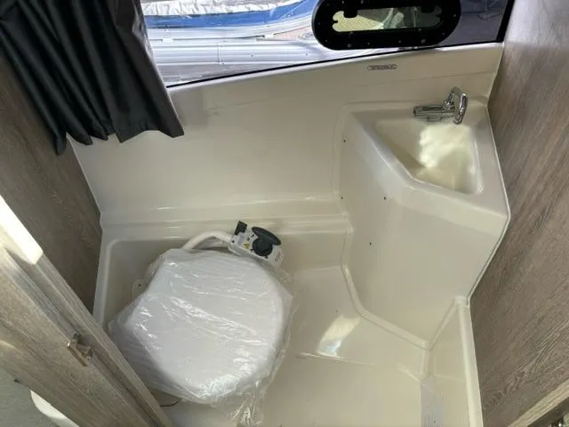 Slide: The Image of 2024 Bayliner TROPHY 25 EXPLORER boat interior bathroom with toilet and sink. - 14