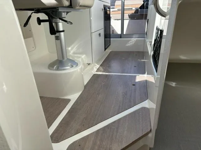 Slide: The Image of 2024 Bayliner TROPHY 25 EXPLORER interior with seating and wood flooring. - 15