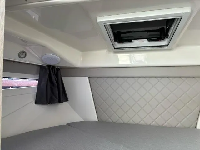 Slide: The Image of 2024 Bayliner TROPHY 25 EXPLORER cabin interior with quilted wall panel and overhead hatch. - 16