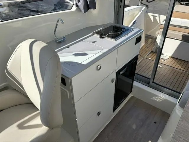 Slide: The Image of 2024 Bayliner TROPHY 25 EXPLORER interior with kitchenette and seating area. - 22