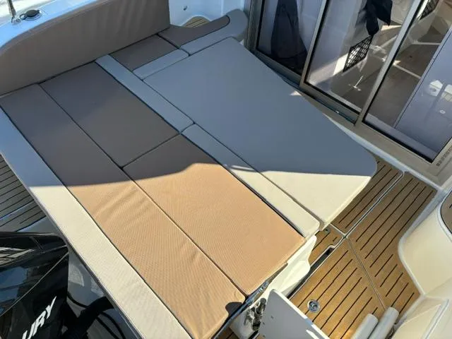 Slide: The Image of 2024 Bayliner TROPHY 25 EXPLORER boat interior with cushioned seating and wooden flooring. - 23