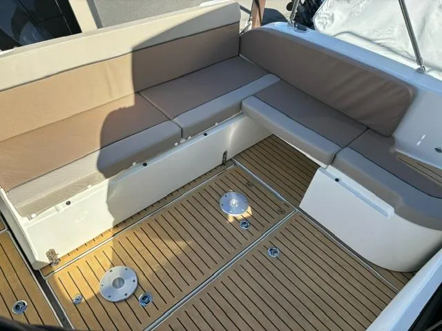 Slide: The Image of 2024 Bayliner TROPHY 25 EXPLORER boat interior with cushioned seating and wooden flooring. - 25