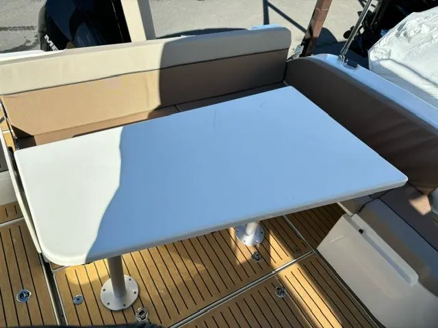 Slide: The Image of 2024 Bayliner TROPHY 25 EXPLORER boat interior with table and seating. - 26