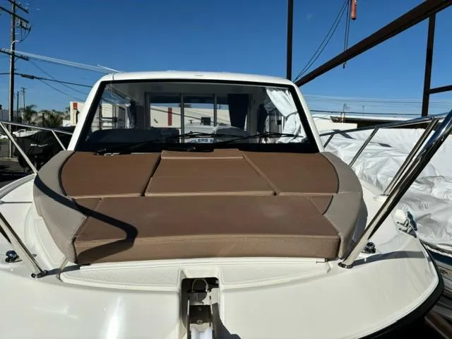 Slide: The Image of 2024 Bayliner TROPHY 25 EXPLORER boat with cushioned deck, docked under clear blue sky. - 5