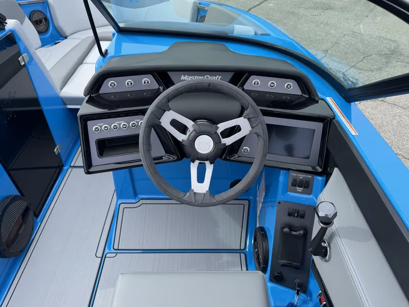 Slide: The Image of 2024 MasterCraft NXT23 boat cockpit with modern steering wheel and dashboard controls. - 11