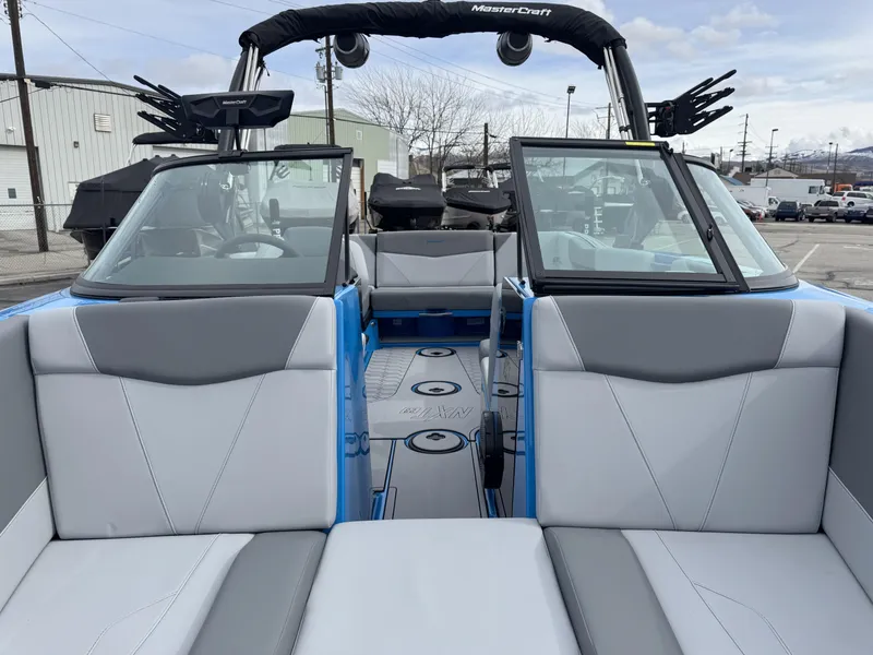 Slide: The Image of 2024 MasterCraft NXT23 boat interior with gray seating and open windshield. - 13