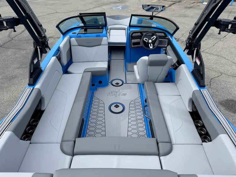 Slide: The Image of 2024 MasterCraft NXT23 boat interior with blue and gray seating, modern design, and spacious layout. - 7