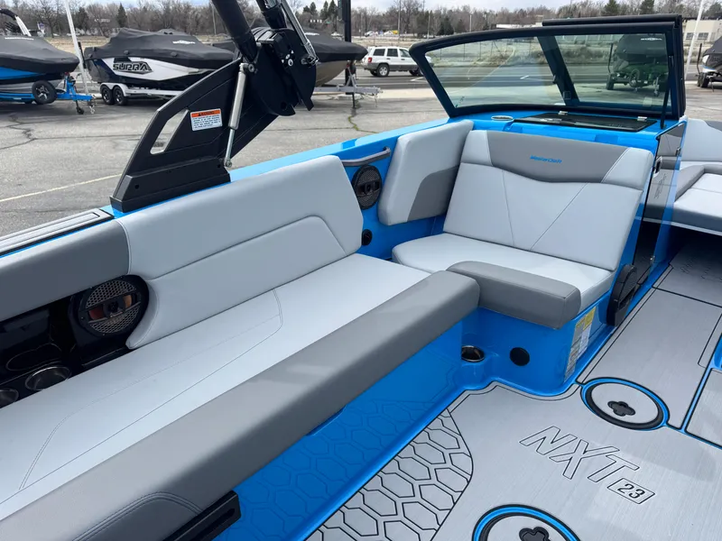 Slide: The Image of 2024 MasterCraft NXT23 boat interior with blue and gray seating, modern design. - 8