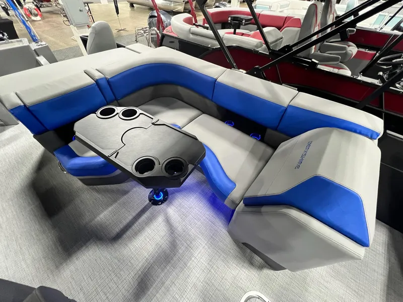 Slide: The Image of 2024 Berkshire 25RFC STS boat interior with blue and gray seating and cupholder table. - 13
