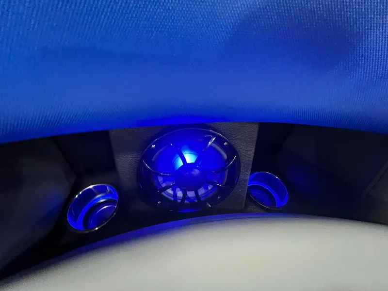 Slide: The Image of Blue LED-lit speaker and cup holders in 2024 Berkshire 25RFC STS boat interior. - 20