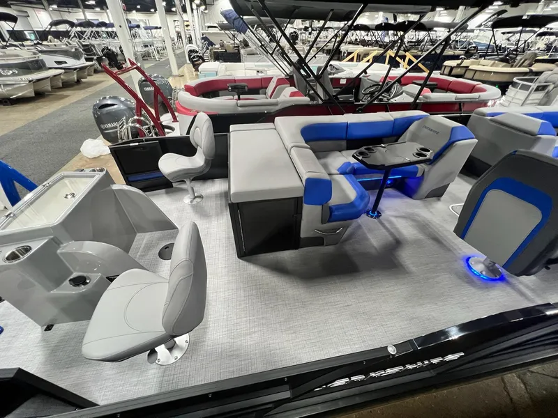 Slide: The Image of 2024 Berkshire 25RFC STS pontoon boat interior with seating and table, displayed at a boat show. - 34