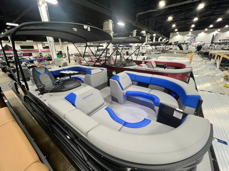 Slide: The Image of 2024 Berkshire 25RFC STS pontoon boat with blue and gray seating at a boat show. - 38
