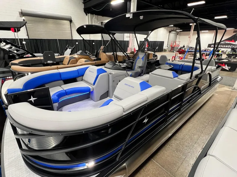 Slide: The Image of 2024 Berkshire 25RFC STS pontoon boat with blue and gray seating on display indoors. - 41